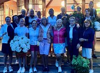 Mehrere Frauen stehen in der Abenddämmerung auf einer Treppe in 2 Reihen mit großem Blumenstrauß
