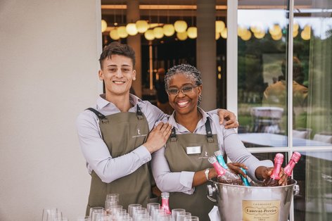 Zwei Mitarbeiterinnen lächeln in Kamera