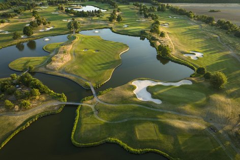 Luftaufnahme von Inselgrün mit Wasserflächen auf Platz St. Leon