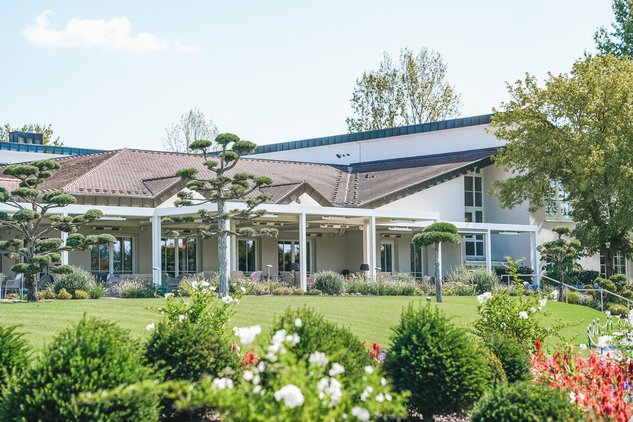 Blick auf Clubhausterrasse mit Wiese im Vordergrund