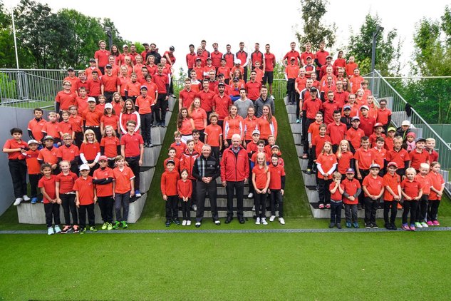 Ehrenpräsident Dietmar Hopp steht mit 100 Kindern auf einer Treppe