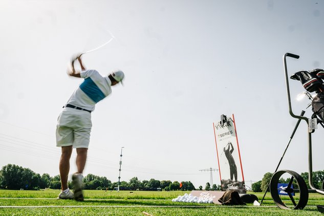 Golfer schlägt auf der Driving Range ab