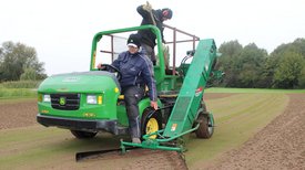 Person fährt mit John Deere Maschine über Golfplatz