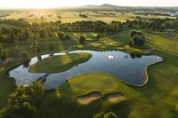 Luftaufnahme von Inselgrün mit Golfteich bei Sonnenaufgang