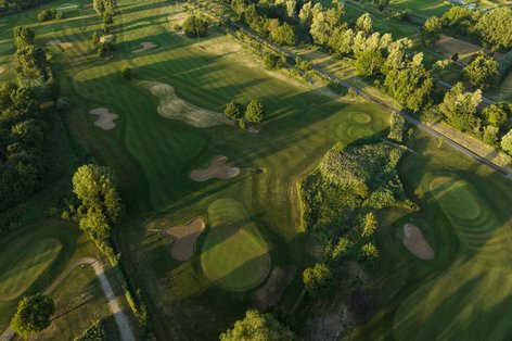 Luftaufnahme von Golfplatz mit Bäumen herum aus Vogelperspektive