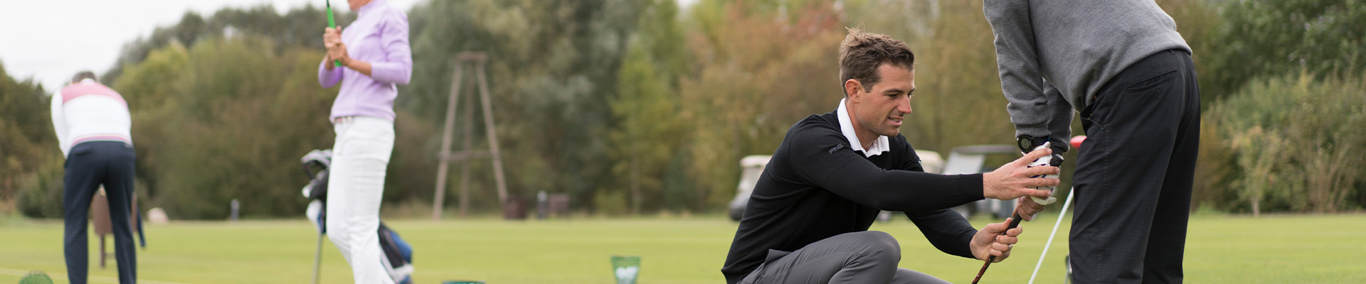 Golftrainer beim Golfunterricht mit Schülern