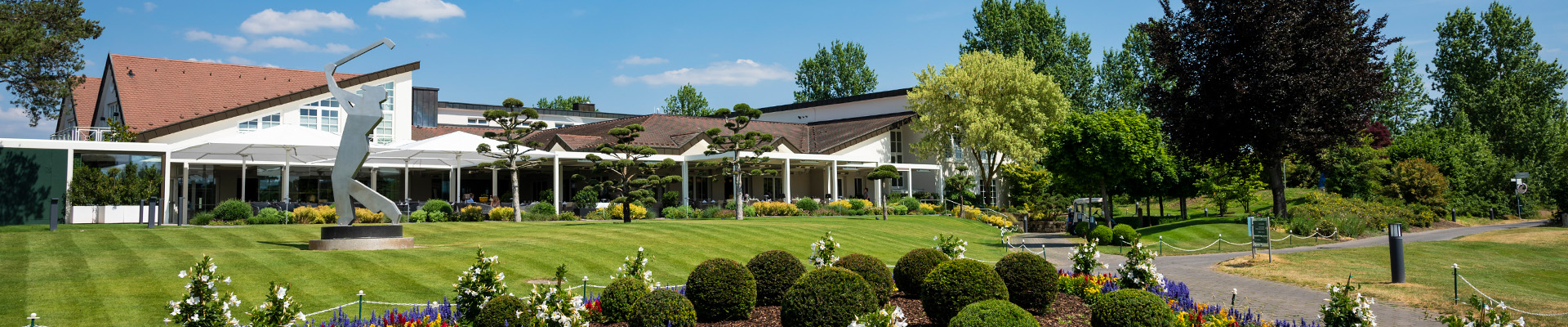 Blick auf Clubhausterrasse mit Wiese im Vordergrund