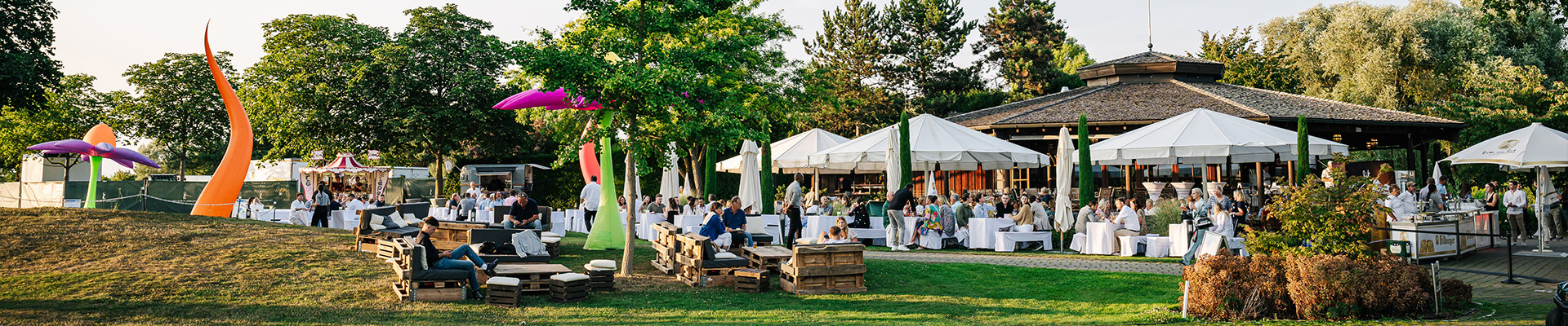 Personenmenge sitzt auf Bierbänken im Freien